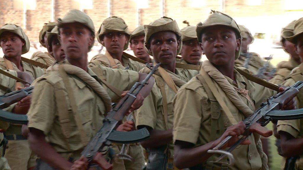 Bewaffnete Soldaten aus Eritrea, die alle in die gleiche Richtung schauen.